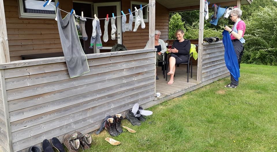 Tøj hænger til tørre langs lille veranda udenfor hytte