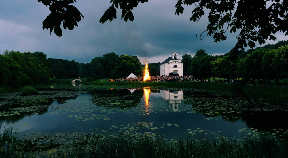 Sø - på den anden side af breden: sankthansbål, mennesker og kirke.