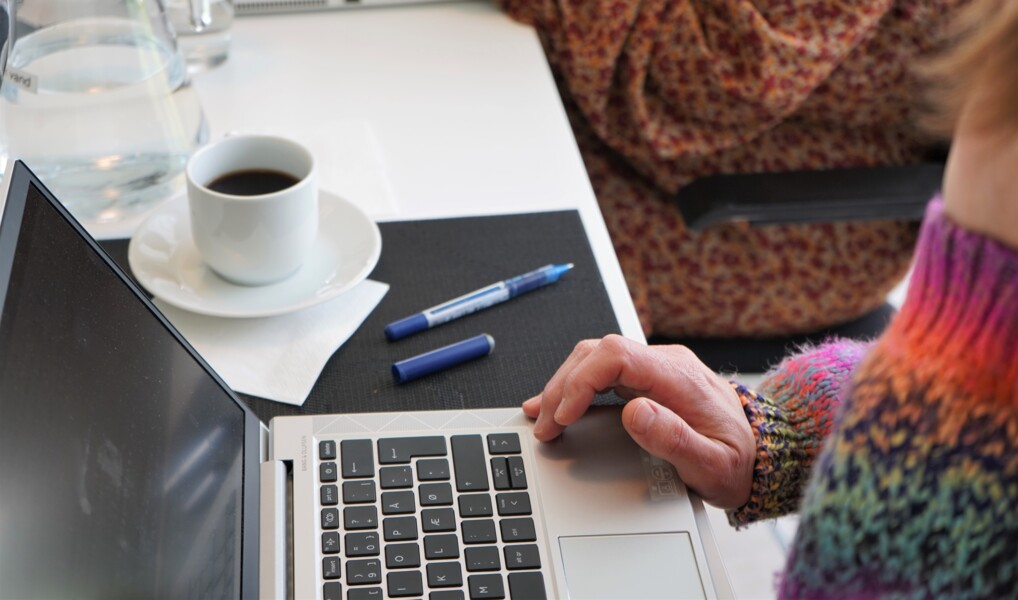 bærbar pc, kaffekop og kuglepen