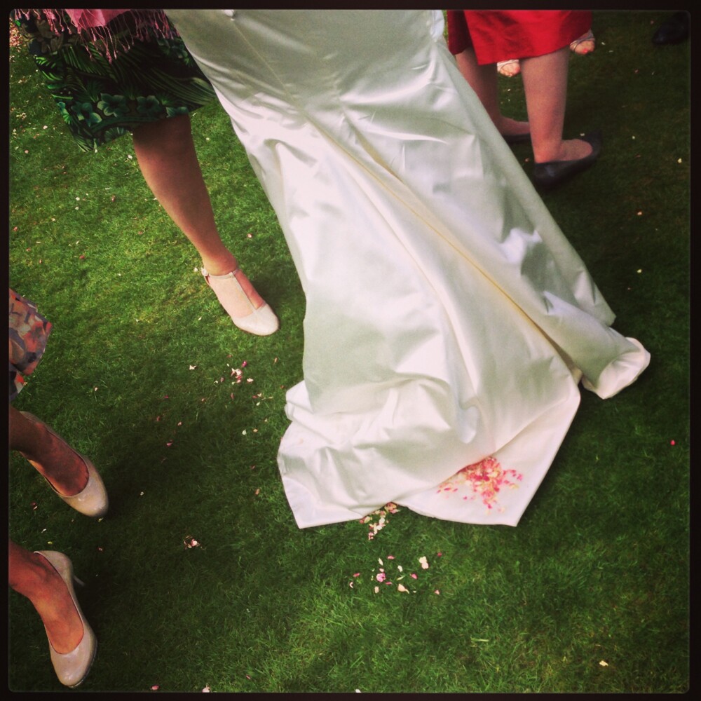 Rosenblade på brudekjoles slæb på græsplæne